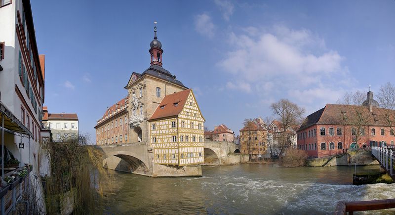Das Alte Rathaus in Bamberg mit Fachwerkanbau und bemalter Fassade auf einer Insel in der Regnitz, beidseitig mit Brücken