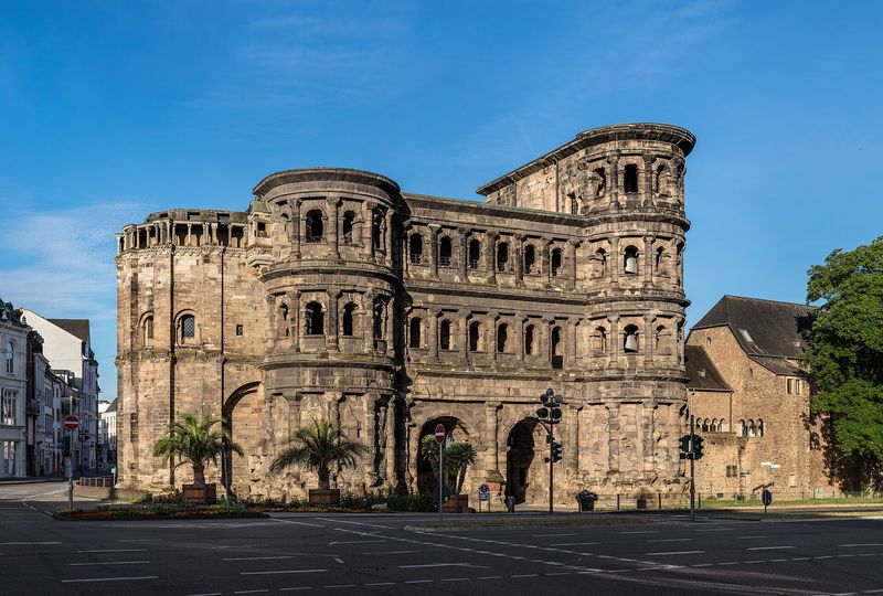Das römische Stadttor Porta Nigra in Trier aus dunklem Sandstein mit Bogenfenstern im Morgenlicht
