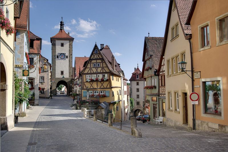 Das Plönlein in Rothenburg ob der Tauber: gelbes Fachwerkhaus an der Gabelung zweier Gassen, links der Siebersturm
